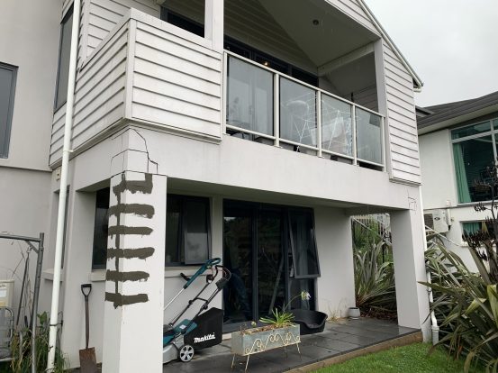 Exterior of a Christchurch home with earthquake cracks and patched repairs on a concrete column.